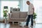 Asian Elderly senior man cleaning dust in living room by Wireless Vacuum cleaner