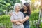 Asian elderly woman with caregiver daughter walking and hug with happy in nature park