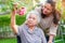 Asian elderly woman enjoy in flower garden with caregiver in park