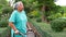 Asian elderly woman holding walking cane To exercise in the park.