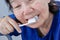 Asian elderly woman trying use toothbrush ,hand tremor.