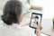 Asian elderly woman virtual happy hour meeting and talking online together with her daughter in video conference with tablet for a