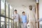 Asian employee greeting residents in hallway of nursing home