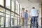 Asian employee greeting residents in hallway of nursing home