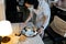 Asian employee in a protective mask holding a tray with scraps of food,waste and used face masks left on plates,girl cleaning the