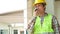 Asian engineer or Architect put on a helmet for safety and use walkie talkie for a talk with a contractor after Inspect Building