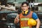 Asian engineer worker with protection suit set hard working in factory handle communication radio looking camera and smile