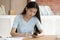 Asian ethnicity schoolgirl do homework seated in library desk