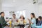 Asian extended family prays together before meals