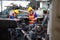 Asian factory engineer wearing yellow hard hat and checking the machine.