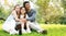 Asian families sit for a picnic at the park. Parents and daughters hug And happy smile. Resting during the Long Weekends Family