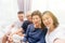 Asian family with adult children and senior parents taking selfie and sitting on a sofa at home. Happy and relaxing family time