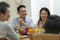 Asian family chatting while eating meal
