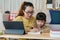 Asian family with a daughter do homework by using tablet with mother help. Happy smile Asia kid while sitting in the living room