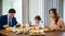 Asian family eating healthy breakfast food on dining table kitchen in mornings together at home