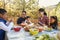 Asian family eating outside at a table on a deck in a forest