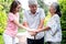 Asian family, an elderly couple and a daughter, all holding hands to encourage each other