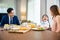 Asian family father, mother with children daughter eating breakfast food on dining table kitchen in mornings