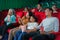 Asian family father, mother, son and grandmother watching movie at the cinema happily on weekends