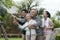 Asian family haapy with smil lovely are watering a tree by tube in garden at outdoor house in morning