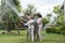 Asian family haapy with smil lovely are watering a tree by tube in garden at outdoor house in morning