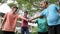 asian family happy smile Exercise together in the morning at the park. fitness group holding hands together for strong health.