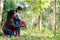 Asian family mom and kid daughter plant sapling tree outdoors in nature spring for reduce global warming growth