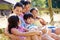 Asian Family Relaxing By Gate On Walk In Countryside