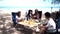 Asian family with senior and kids relaxing and camping on tropical beach during summer holiday. Togetherness and outdoor activity