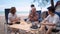 Asian family with senior and kids relaxing and camping on tropical beach during summer holiday. Togetherness and outdoor activity