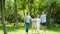 Asian family walking & laughing in park in sunny summer in slow motion