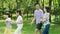 Asian family walking in natural park in summer, smiling and looking at each other