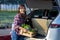 Asian farmer is delivering freshly harvest of organics vegetable box into the customer trunk car for supporting local business