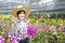 Asian farmers. Happy Female farmers are harvesting orchid flowers for sale. Beautiful woman working in the orchid farm. Purple