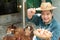 Asian farmers hold an eggs basket with their left hand and their right hand holding egg and holding up. At a chicken farm in their