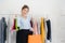 Asian fashion female blogger online influencer holding shopping bags and lots of clothes on clothes rack for recording new fashion