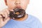Asian fat boy holds a chocolate-coated donut He enjoys eating.