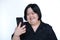 Asian fat girl with disabilities or children with Down syndrome Playing on the phone and smiling happily on white background.