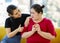 Asian fat woman feels guilty when she wants to eat an apple while her friend sitting beside her and cheer up for her to eat good