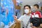 Asian Father and child wearing protective medical mask during covid-19 outbreak, Dad holding son looking at fish in aquarium, New