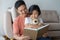 Asian father and daughter read books the floor in the house, Self-learning concept