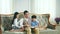 Asian father daughter and son reading book together at home