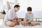 Asian father and son concentrate on playing wooden block together at home for edutainment concept