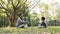Asian father and son sitting on grass chatting in park