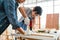 Asian father and son work as a woodworker or carpenters. Close up hands of the father and his son drill holes in a wooden plank