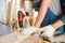 Asian father and son work as a woodworker or carpenters. Close up hands of the father and his son drill holes in a wooden plank