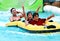 Asian father and sons having fun tubing at a waterpark