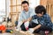 Asian father is teaching his son woodworking