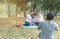 Asian father use digital camera take photo of his wife and son and grandma in park.Leisure time of asia family have picnic in park