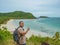 Asian fatty backpacker stand on view point on top of the island with idyllice beach ocean and blue sky in vacation time